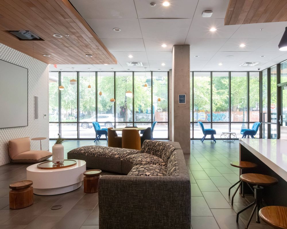 Skyloft Austin resident lounge with comfortable seating and floor-to-ceiling windows.