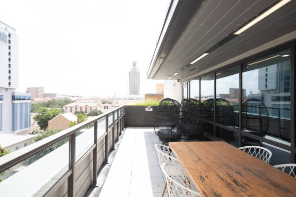 Skyloft Austin shared rooftop terrace with seating and a view of the UT Tower.